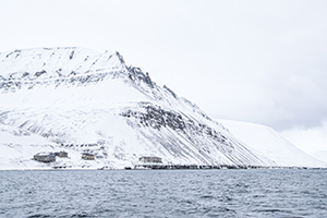 verschneite Bergkette und kleine Häuser auf Svalbard, Barentsburg